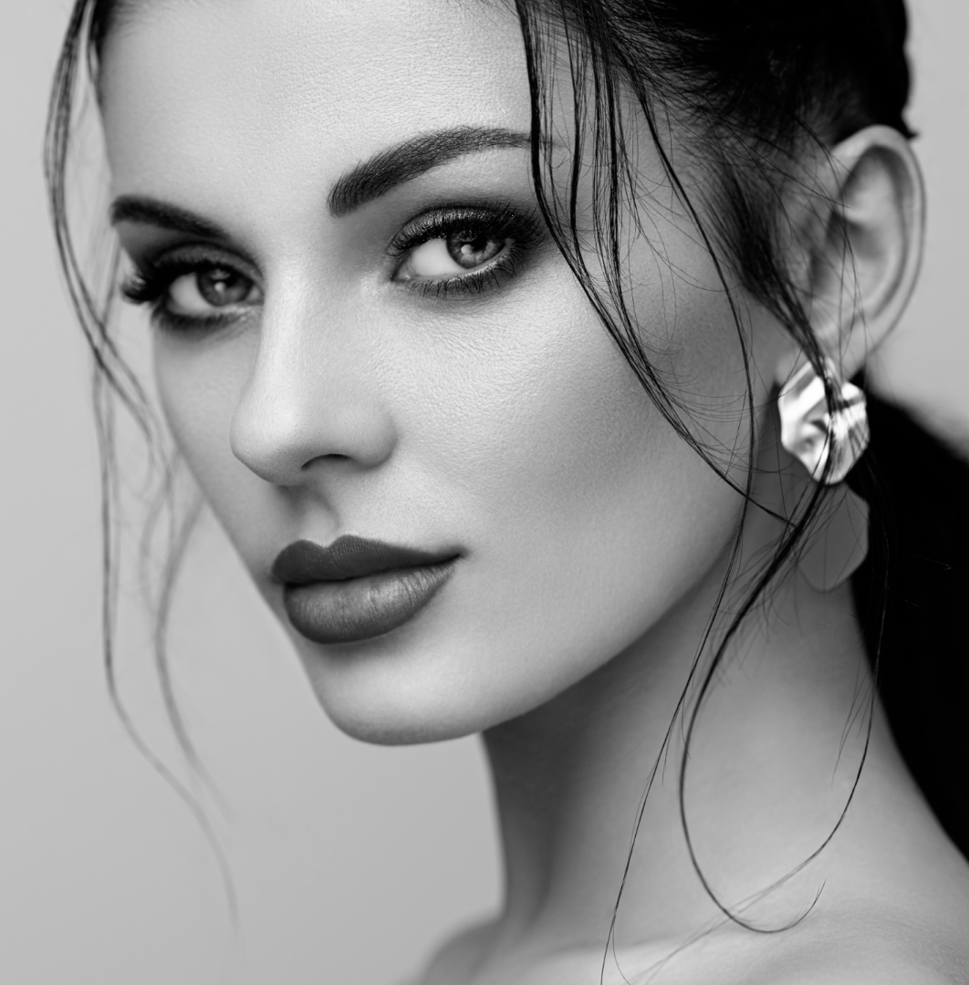 A stunning woman with long hair and elegant earrings.