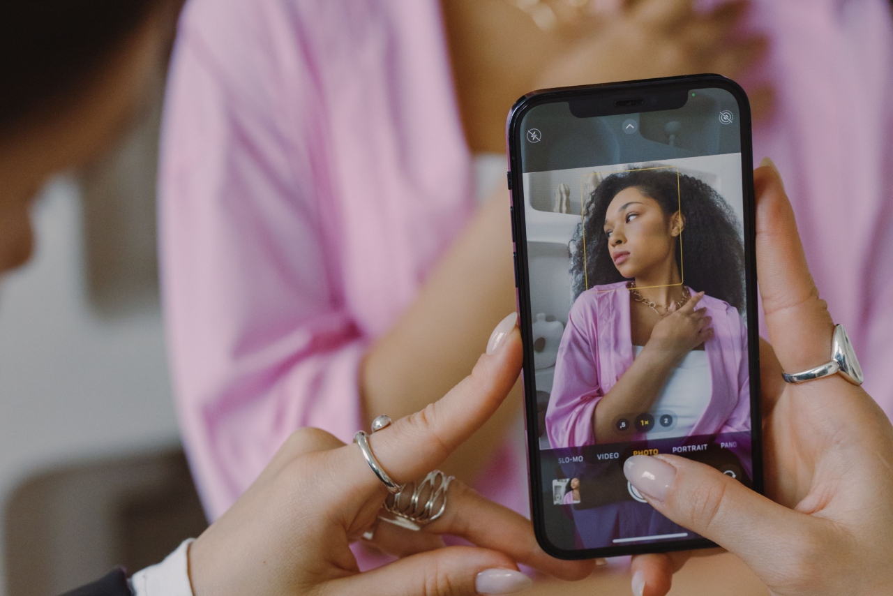a woman taking a photo of another woman using phone
