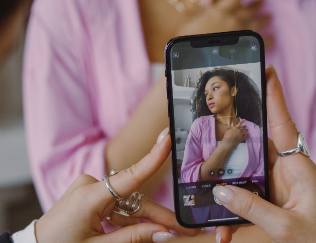 a woman taking a photo of another woman using phone